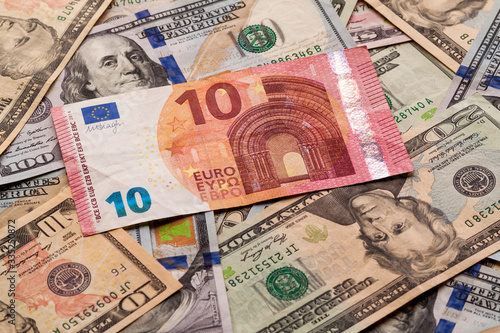 Money and finances concept. Ten euro new bill on colorful abstract background of American national currency, dollar banknotes.