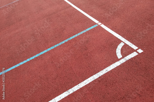 Close-up of white marking lines of outdoor basketball court. © bilanol