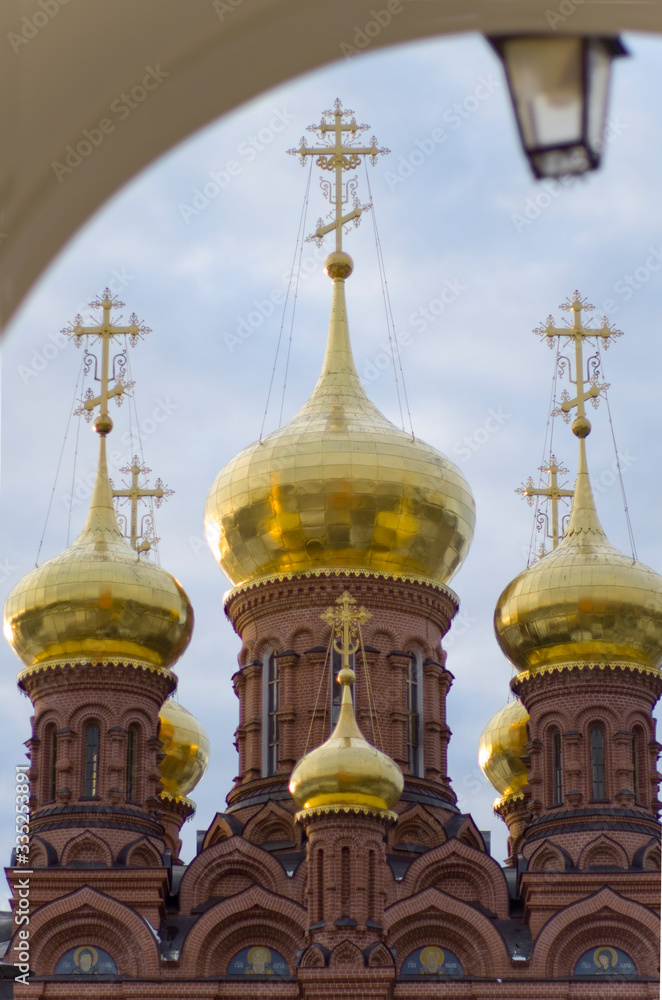 The Chernigovsky skete in Sergiev Posad, Russia, golden domes on the  huge belfry above the gate