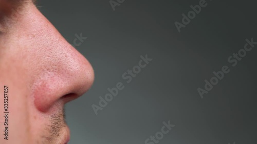 Close up of a man smelling with his nose