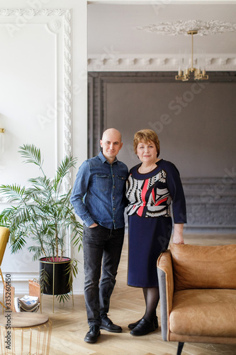 Happy mother and her son hugging standing in the interior