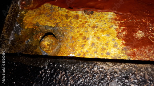 rusty screw between black, yellow and red