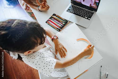 young caucasian girl drawing at home, on-line art calss, home schooling, stay home education photo