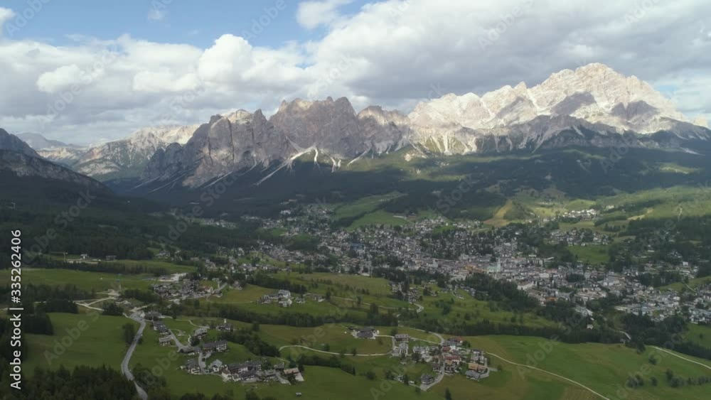 Aerial of a Small Town in the Italian Dolomites during Summer with Mountains in the Background Aerial of a Small Town in the Italian Dolomites during Summer with Mountains in the Background