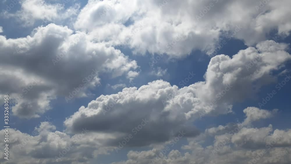 Blue summer sky with dense thick rain clouds moving across the heavens. Fast cloud formation and movement creating a surreal time lapse. Blue summer sky with dense thick rain clouds moving across the heavens. Fast cloud formation and movement creating a surreal time lapse.