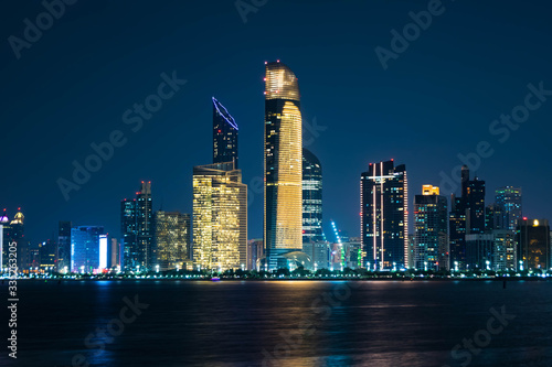 Beautiful City night view of Abu Dhabi financial and commercial district, taken during blue hour, view from marina backwater, United Arab Emirates, luxury life style, business in UAE, .