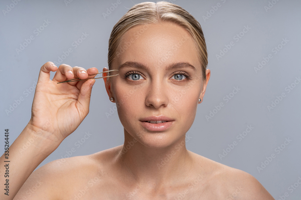 Fototapeta premium Close up of kind girl that correcting her eyebrows