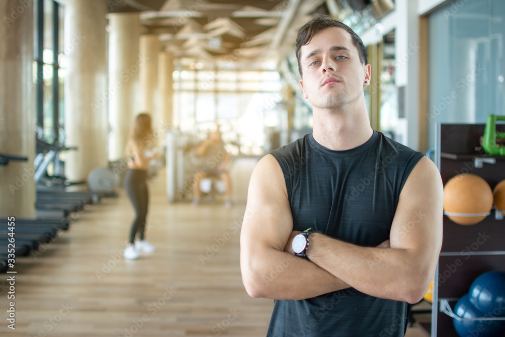 Obraz premium Personal trainer with is arms crossed in a gym