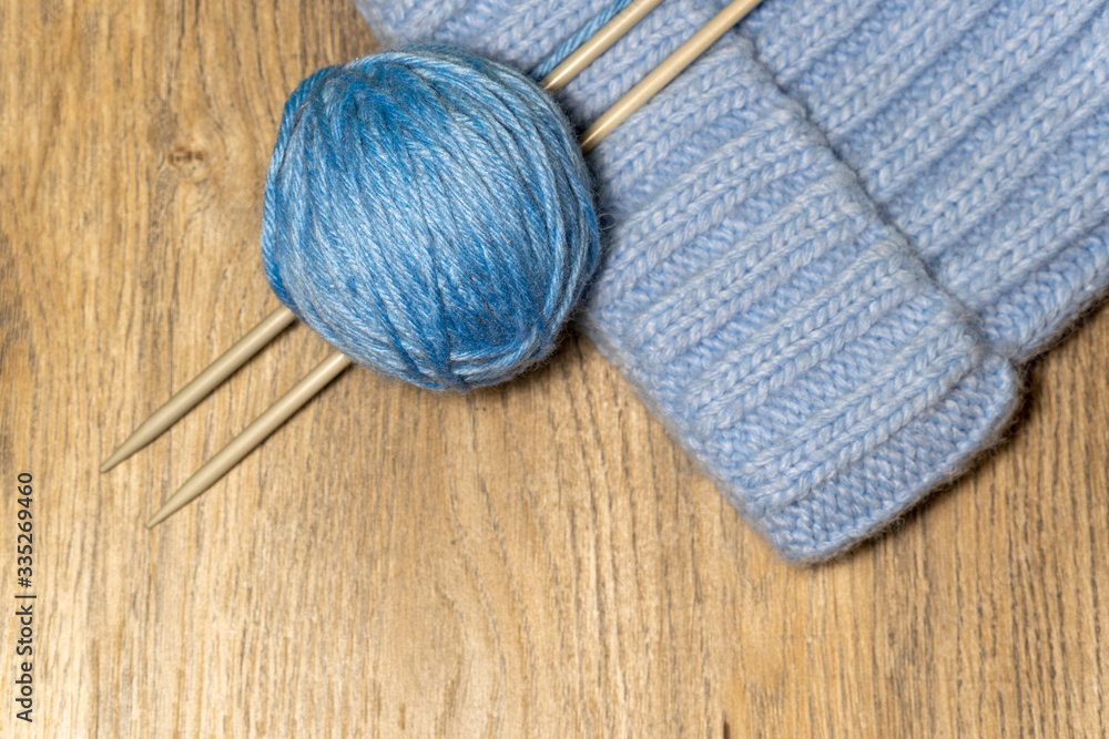 Knitting yarn and knitting needles on wooden background. Handmade hobby. 