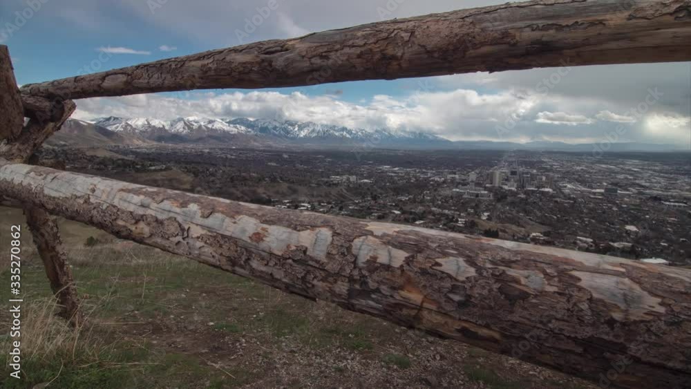 Timelapse sliding along rustic wooden fence looking out over downtown salt lake as a storm rolls in. Panning right from snowy mountains to downtown. Rain lands on lens at end of shot. Timelapse sliding along rustic wooden fence looking out over downtown salt lake as a storm rolls in. Panning right from snowy mountains to downtown. Rain lands on lens at end of shot.