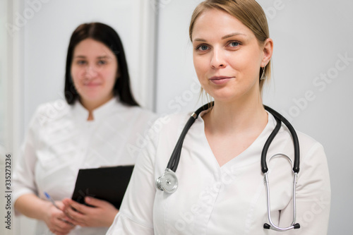 Female doctor and nurse with stethoscope indoors