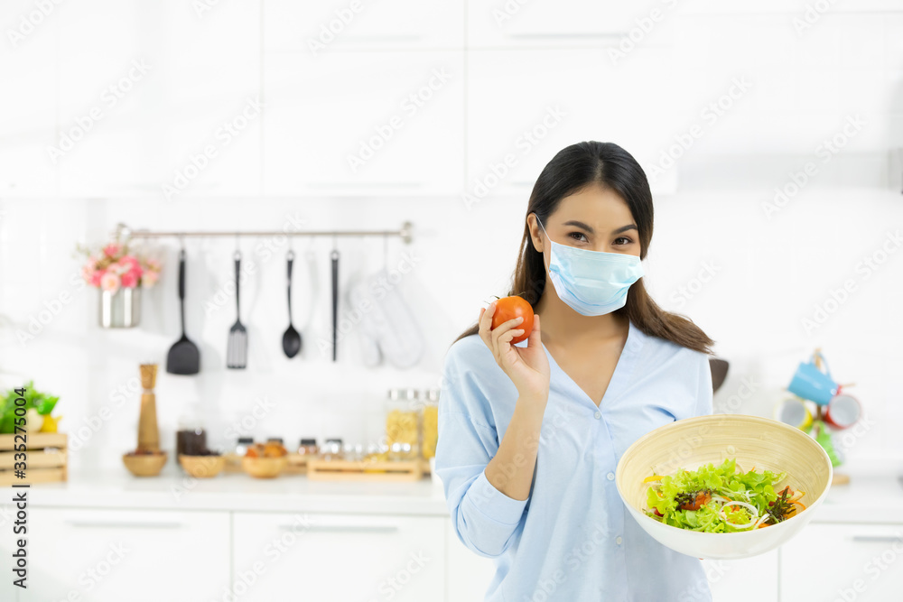 Young Woman Cooking delicious food in the kitchen and wearing face  protection mask to anti saliva, cough. Stay at home during the COVID-19  self-quarantine 14 days. Stock Photo | Adobe Stock