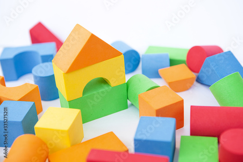 A toy house made of colored cubes. A house made of blocks on a white background.