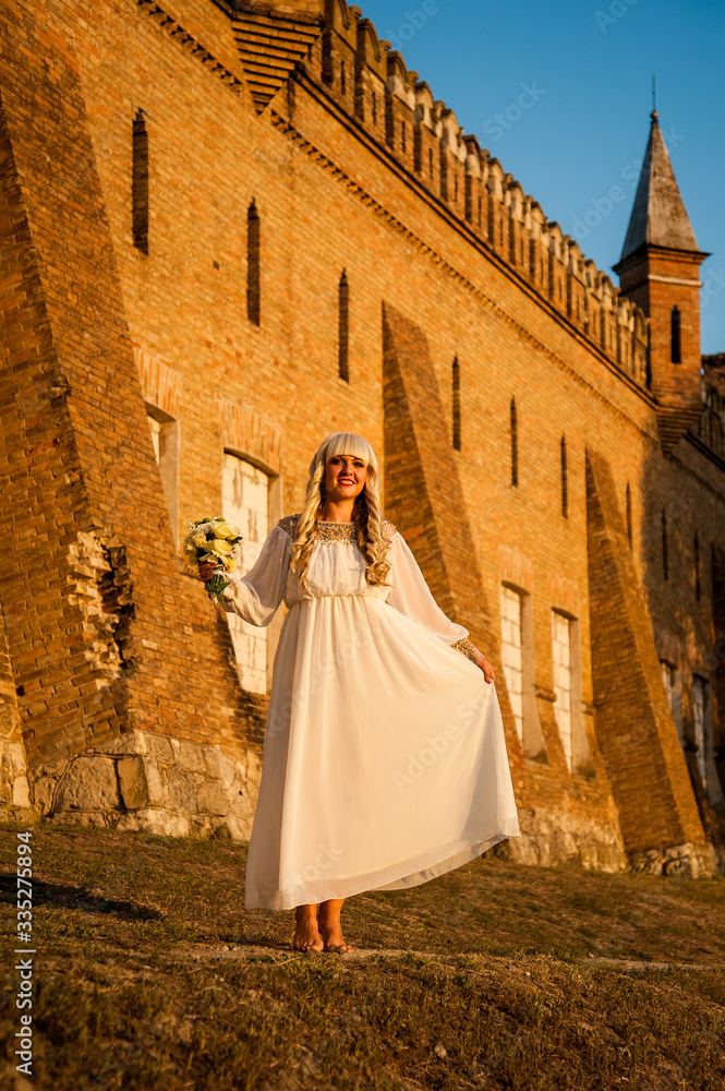 blonde girl in a white dress on nature near architectural monuments in the open air blonde girl in a white dress on nature near architectural monuments in the open air
