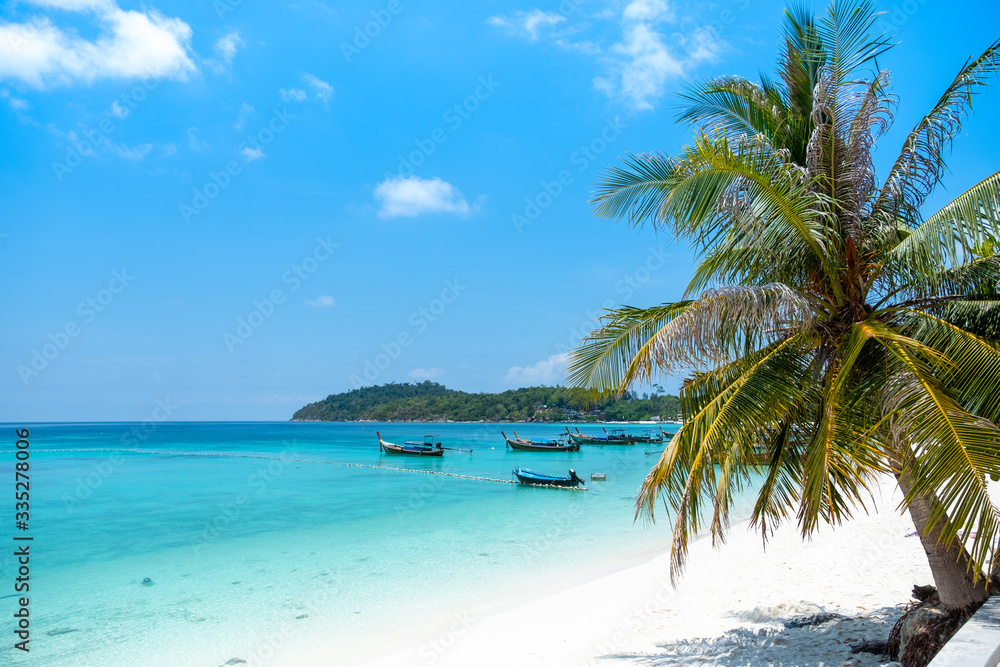 Beautiful tropical beach and ocean with boat and beautiful clear blue sky background