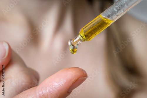 Woman is applying moisturizing body oil on her finger