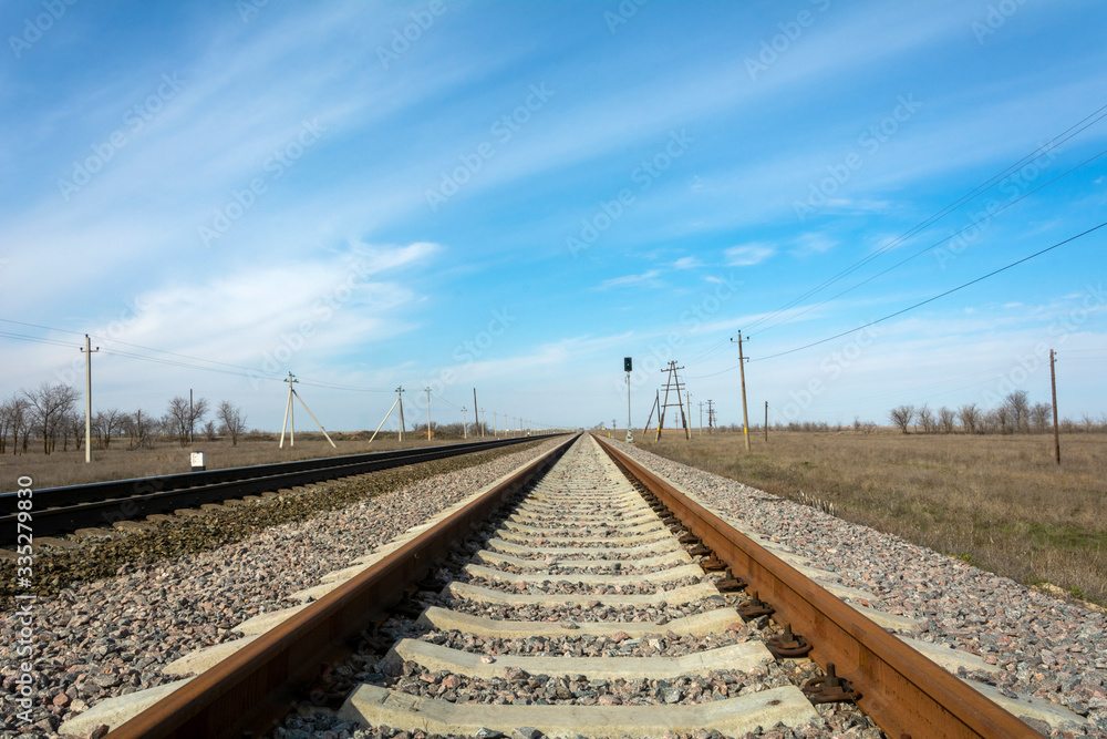 Rails close-up, the railway goes to the horizon, bright blue sky. The concept of free movement, freedom, infinity