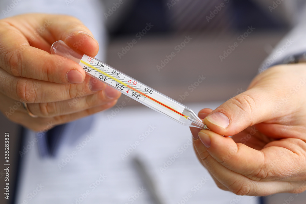 Male doctor holding in hand thermometer Male doctor holding in hand thermometer
