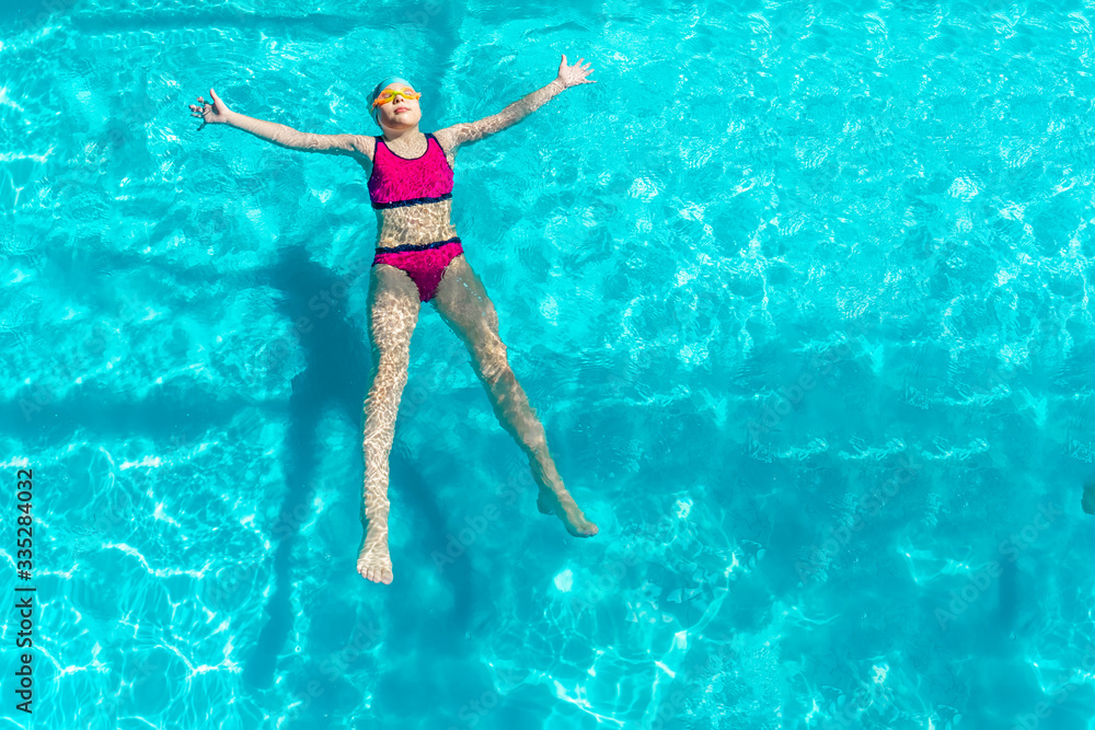girl swims in a blue pool