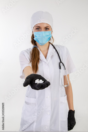 A doctor in a white coat holds out a medication.