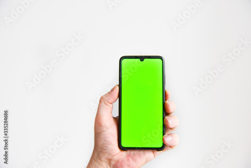 a hand with a smartphone with a green background