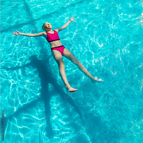 girl swims in a blue pool © Вера Щербакова