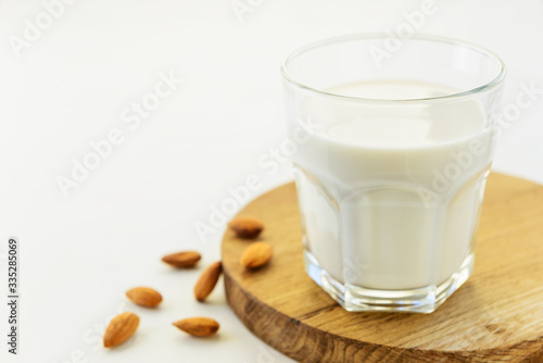 Almond milk in a glass on a wooden board.