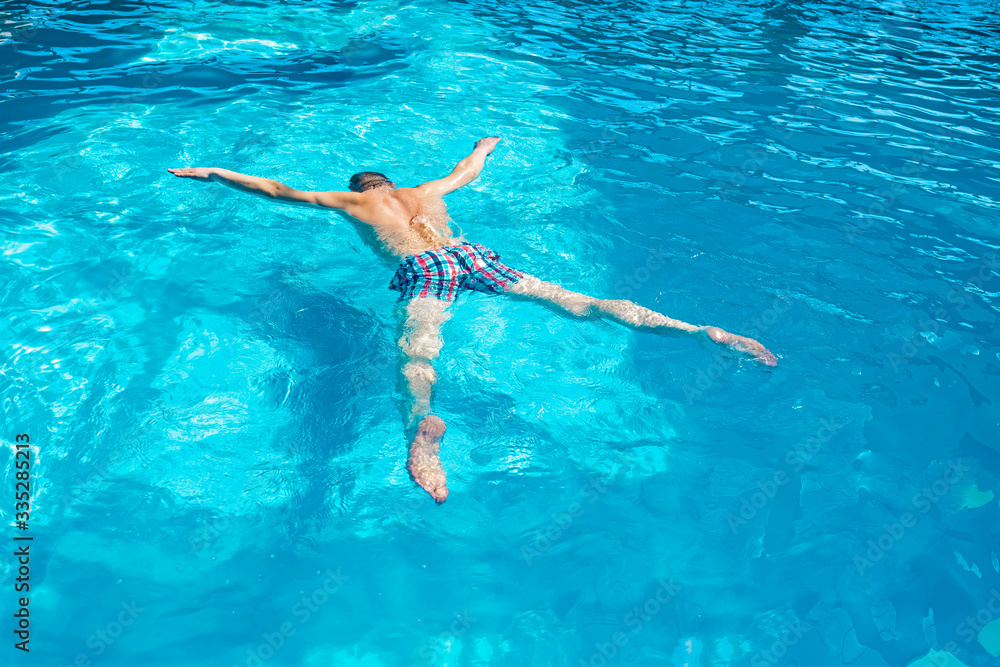 a man in the pool swims with an asterisk