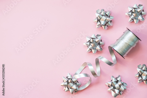 Silver gift bow isolated on pink background.set of decorative bows. Christmas wrapping paper with ribbons. Decoration for presents, gift boxes for holiday, Valentine celebration, birthday surprise.