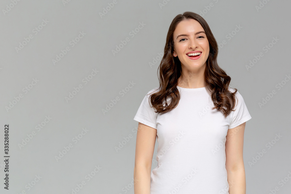 Enjoy life to fullest. Portrait of attractive carefree european female with ginger hair, playing with strands and laughing out loud over gray background, tilting head up, having fun and being amused Enjoy life to fullest. Portrait of attractive carefree european female with ginger hair, playing with strands and laughing out loud over gray background, tilting head up, having fun and being amused