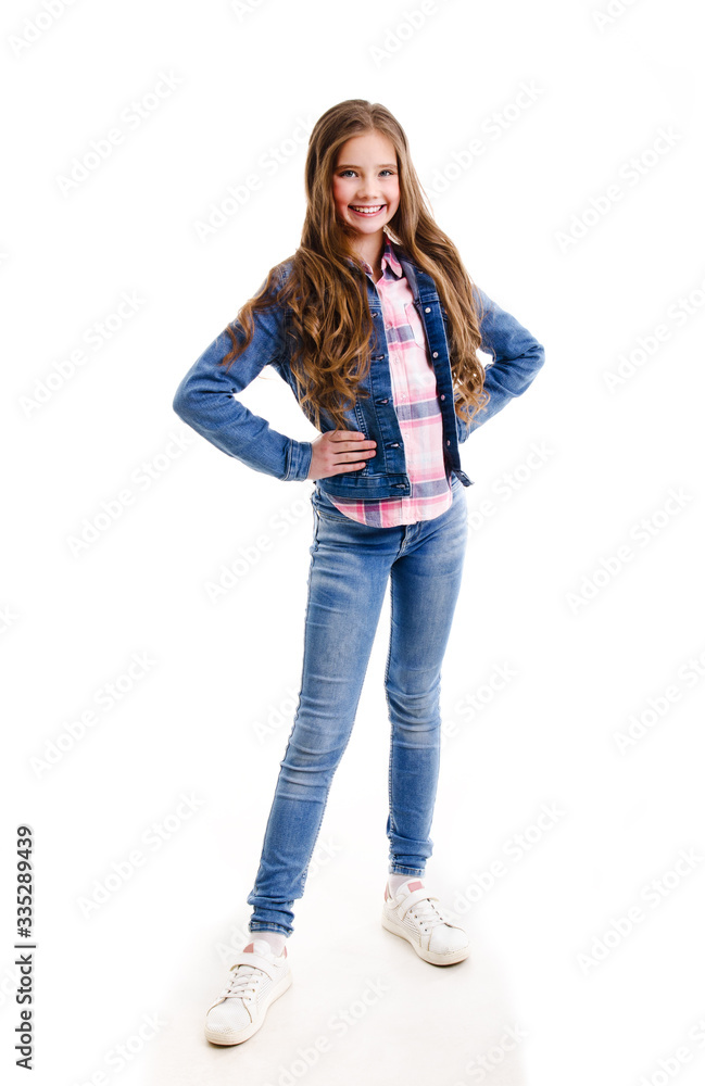Portrait of adorable smiling little girl child preteen standing in jeans isolated Portrait of adorable smiling little girl child preteen standing in jeans isolated