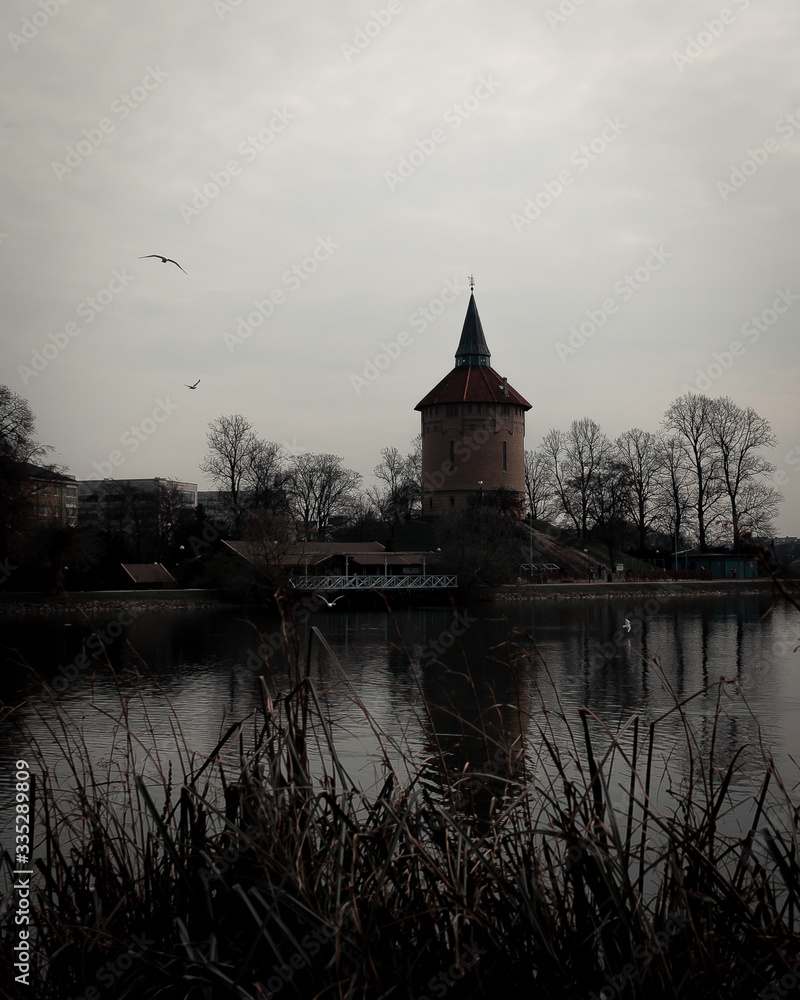 Obraz premium An old water tower is placed on a small hill in a public park called Pildammsparken in Malmö, Sweden. Here seen on a dark spring day.