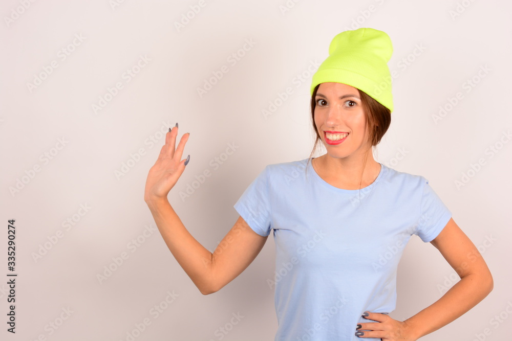 woman with make-up in a yellow hat smiles in a blue t-shirt woman with make-up in a yellow hat smiles in a blue t-shirt