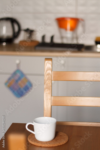 white mug against the kitchen background on the table with a blurred background. composition kitchen