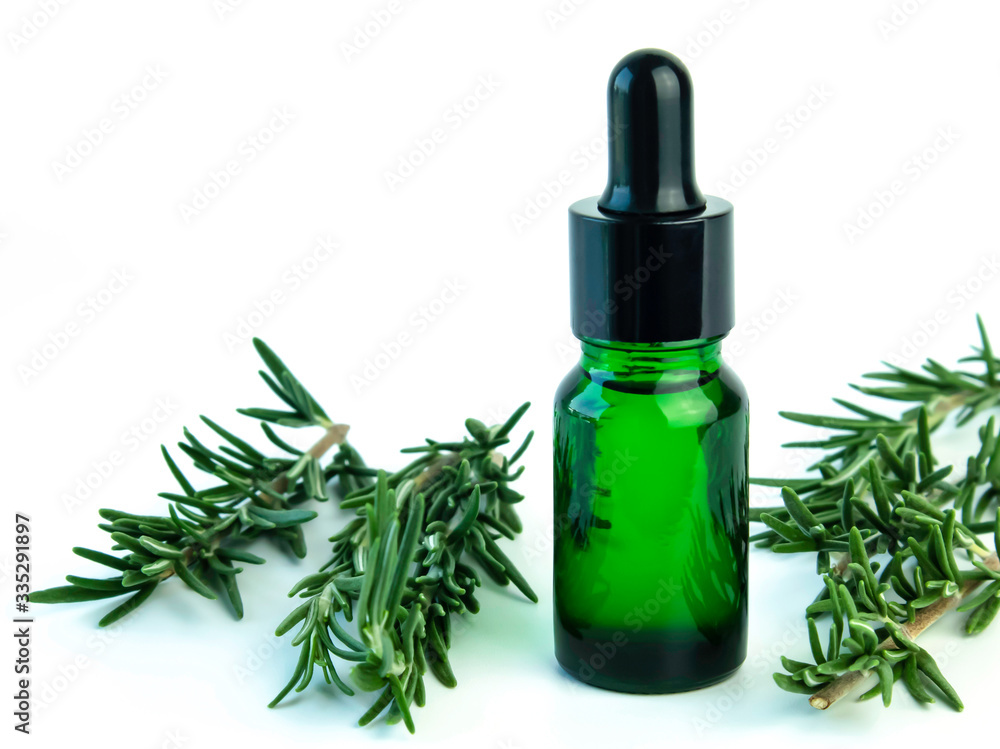 Bottle of rosemary essential oil with fresh green leaves on white background ,free space for your text. Bottle of rosemary essential oil with fresh green leaves on white background ,free space for your text.