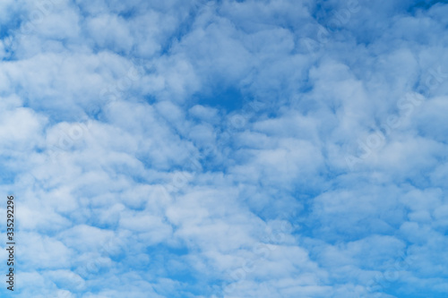 White cumulus clouds on a blue sky. Bright day Designer background to insert.