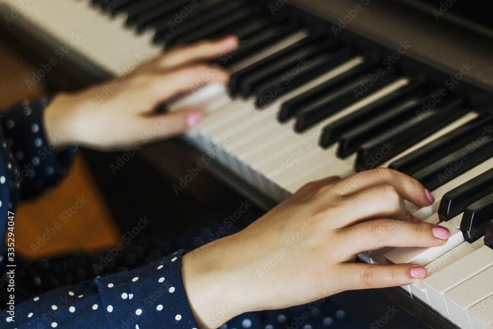 Fototapeta premium Girl's hands on the piano keys. Classical music. Musical rehearsal.