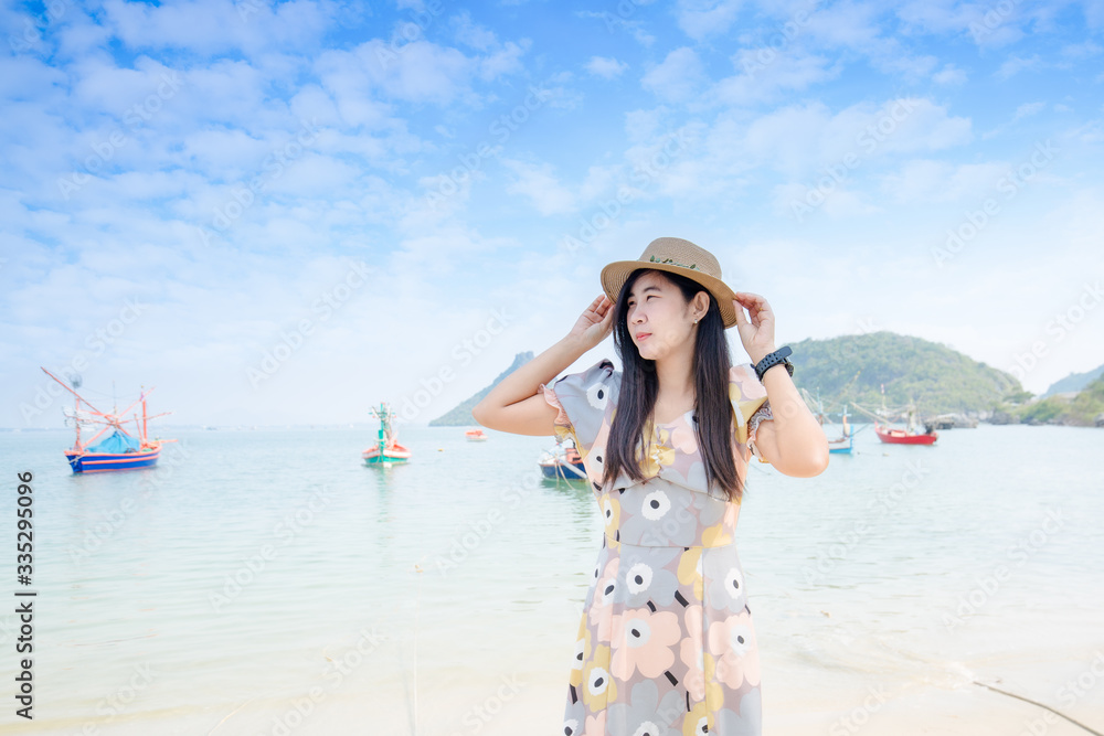 Portrait young asian woman walk smile and happy on the beach sea and ocean for leisure travel in holiday vacation