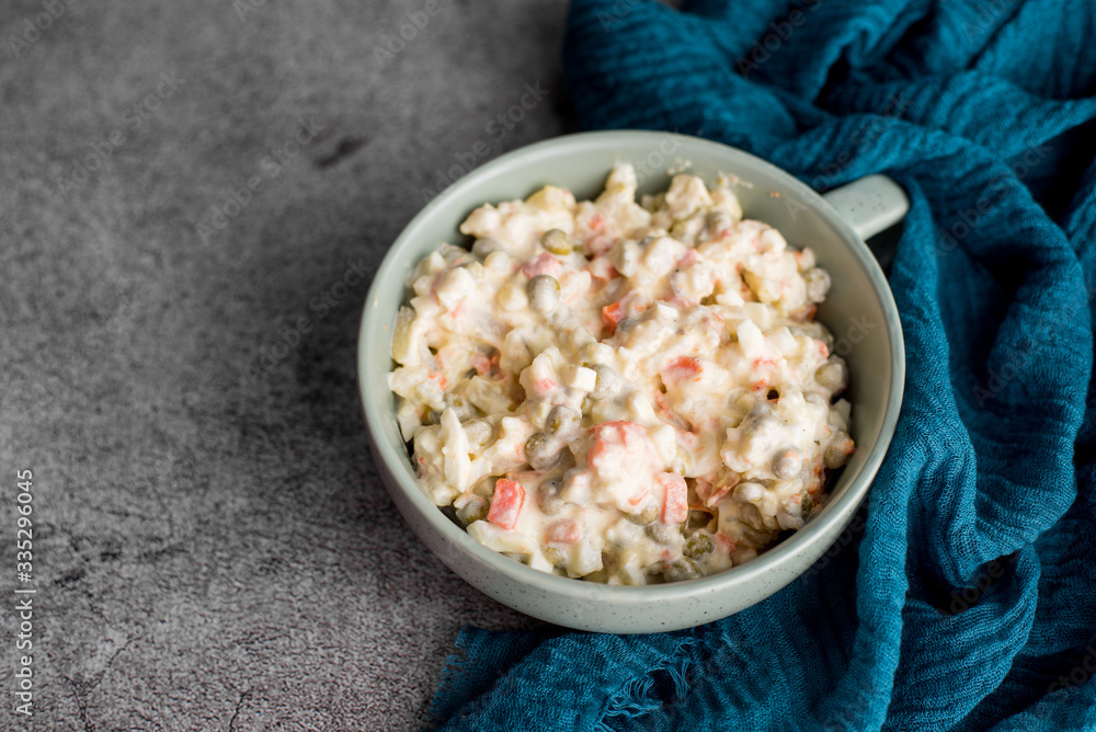 Bowl of traditional Russian salad called Olivie, Russian New Year or Christmas salad on wooden background. Salad from cooked vegetables. Potato salad. Bowl of traditional Russian salad called Olivie, Russian New Year or Christmas salad on wooden background. Salad from cooked vegetables. Potato salad.