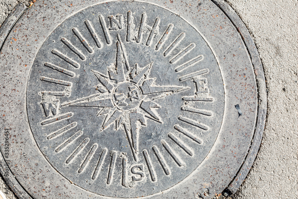 Sewer manhole with designation of cardinal points.