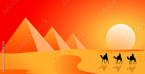 Camel travelers in the desert of the Pyramids. Camel caravan follows in the desert against the backdrop of a sunny sunset. The pyramids. Sand desert