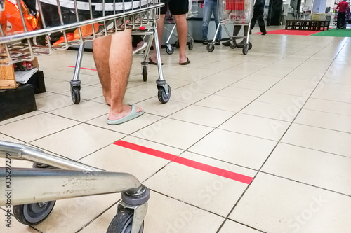 Social distancing being practiced at supermarket payment counter, with 1 meter gap between people in queue.