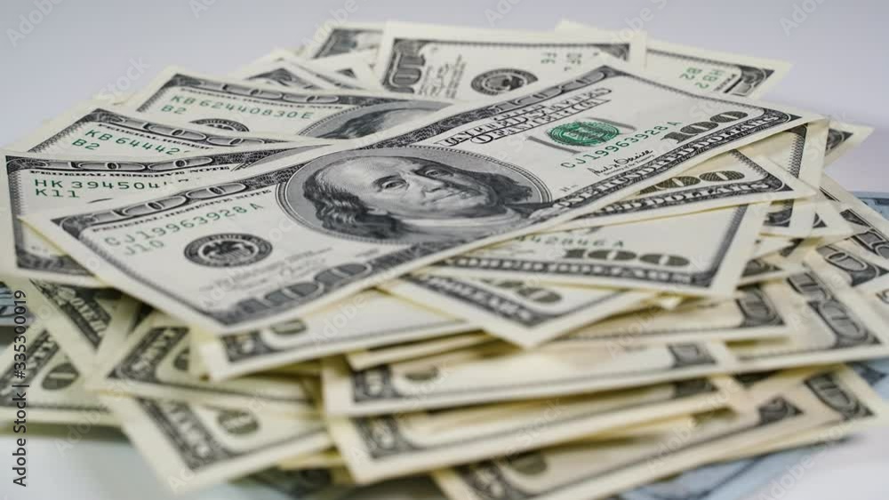 A pack of dollars increases in quantity on a white table. Stop motion A pack of dollars increases in quantity on a white table. Stop motion