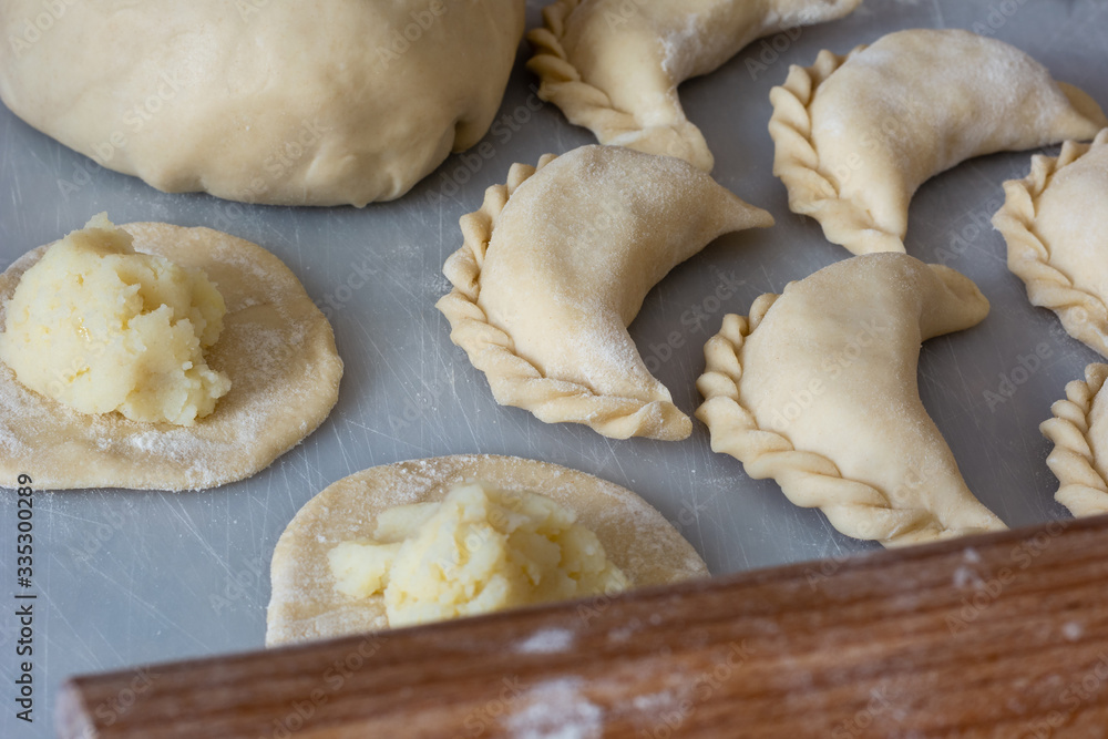 Uncooked vareniki (dumplings) with mashed potato, traditional Ukrainian food