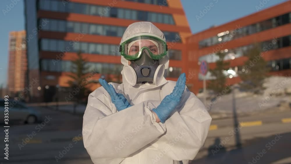Covid-19 Coronavirus quarantine. COVID-19 epidemic. Doctor scientist wearing in PPE biohazard personal protective equipment clothing suit show stop hands gesture for stop corona virus outbreak. 4 K Covid-19 Coronavirus quarantine. COVID-19 epidemic. Doctor scientist wearing in PPE biohazard personal protective equipment clothing suit show stop hands gesture for stop corona virus outbreak. 4 K