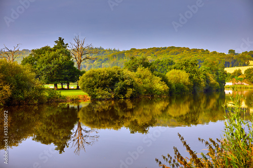 Image of the Vilaine Riverside with trees, water and reflections.