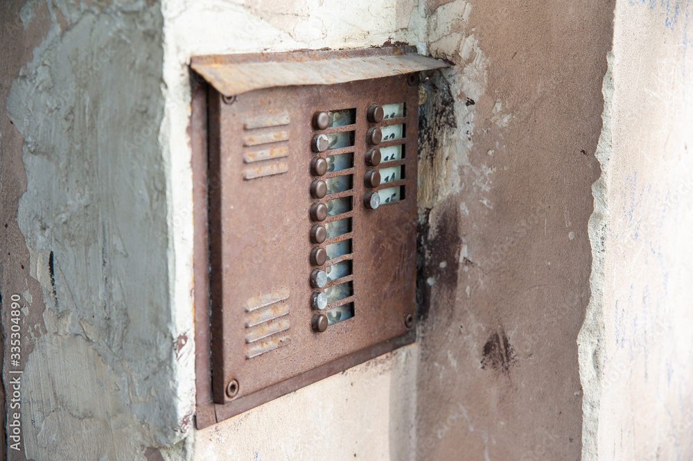 Closeup of obsolete brown doorbell with nameplates and buttons