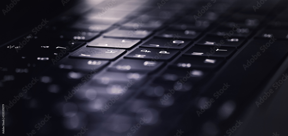 keyboard of a modern notebook, laptop on the dark closeup