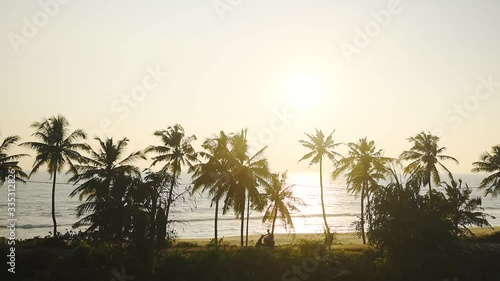 A Motorcycle Passing Through The Varkala Beach With Coconut Trees During Sunset In Thiruvananthapuram District, India. -wide shot photo