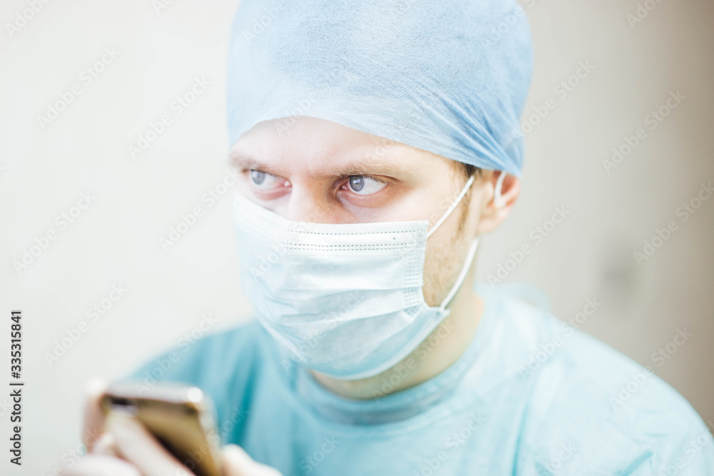 Male doctor in medical uniform and mask ponders at the clinic. medical issue. Male doctor in medical uniform and mask ponders at the clinic. medical issue.